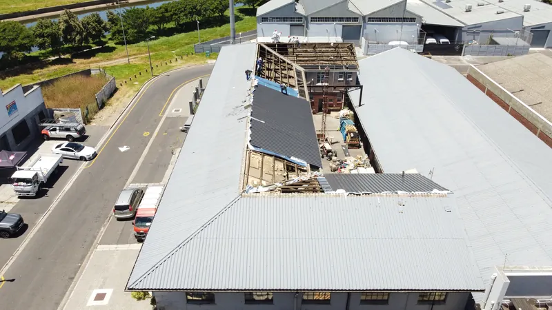 Oblique view of the roof during replacement, with new dark sheeting and exposed framing