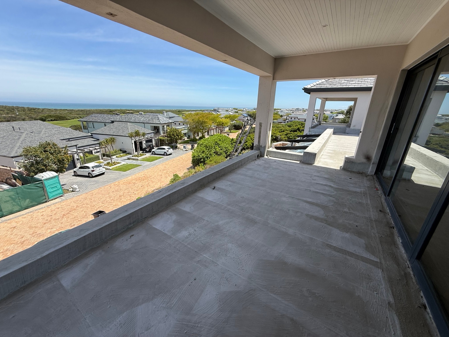 Prepared upper balcony surface at 34 Tradewinds, with the doorway and balcony edge visible